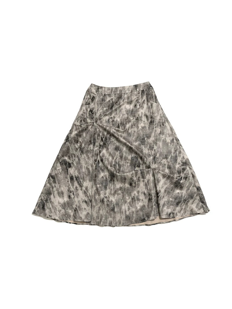 NEXT PASSPORT gray crinkled-print midi skirt isolated flat-lay front view.