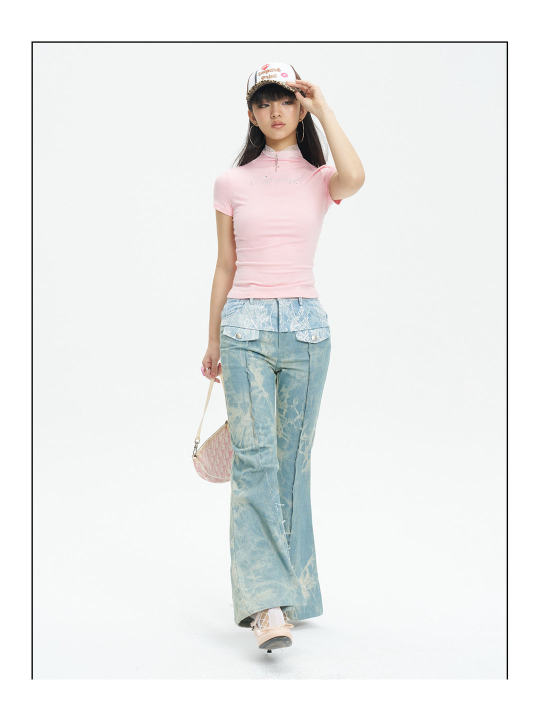 NEXT PASSPORT printed lace-panel flared jeans in pale blue — walking modeled view showing the flare in motion.
