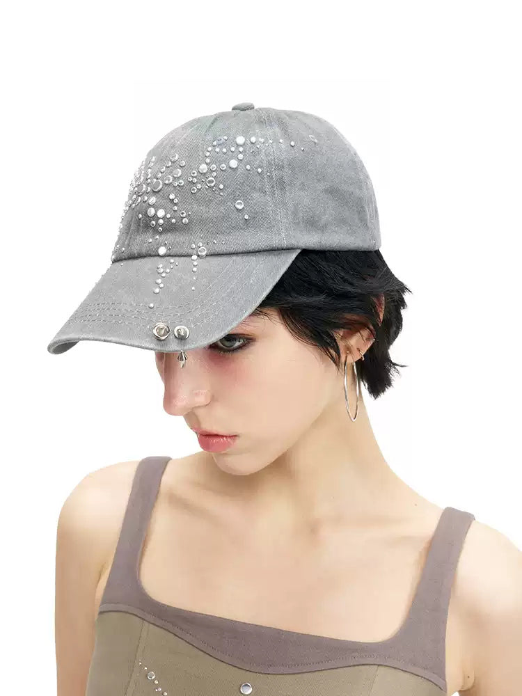 NEXT PASSPORT butterfly rhinestone eyelet baseball cap — front modeled close-up showing the rhinestone butterfly and pierced hardware