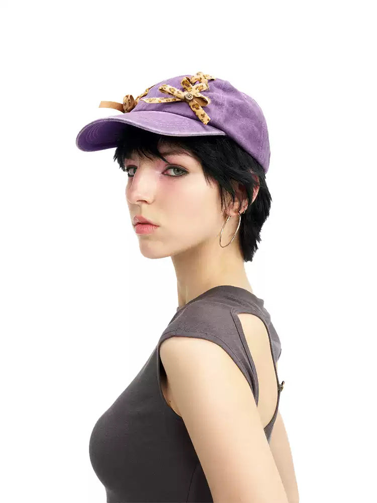 NEXT PASSPORT purple leopard lace-up baseball cap worn side view