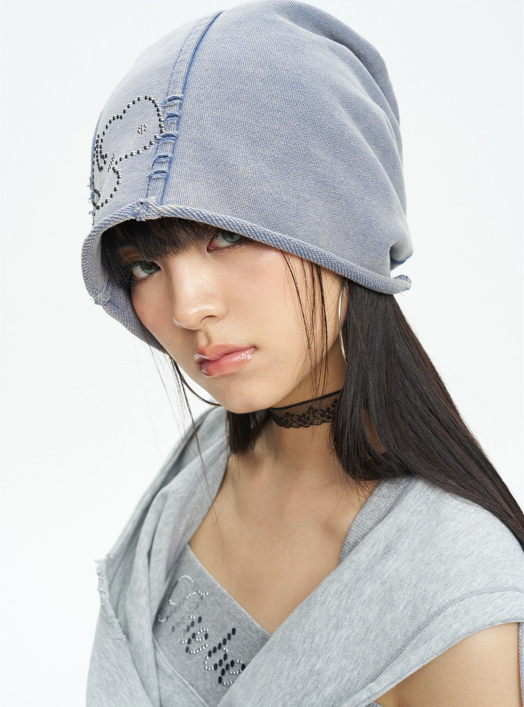 NEXT PASSPORT washed rhinestone blue-gray slouch beanie — front close-up showing the rhinestone scrollwork