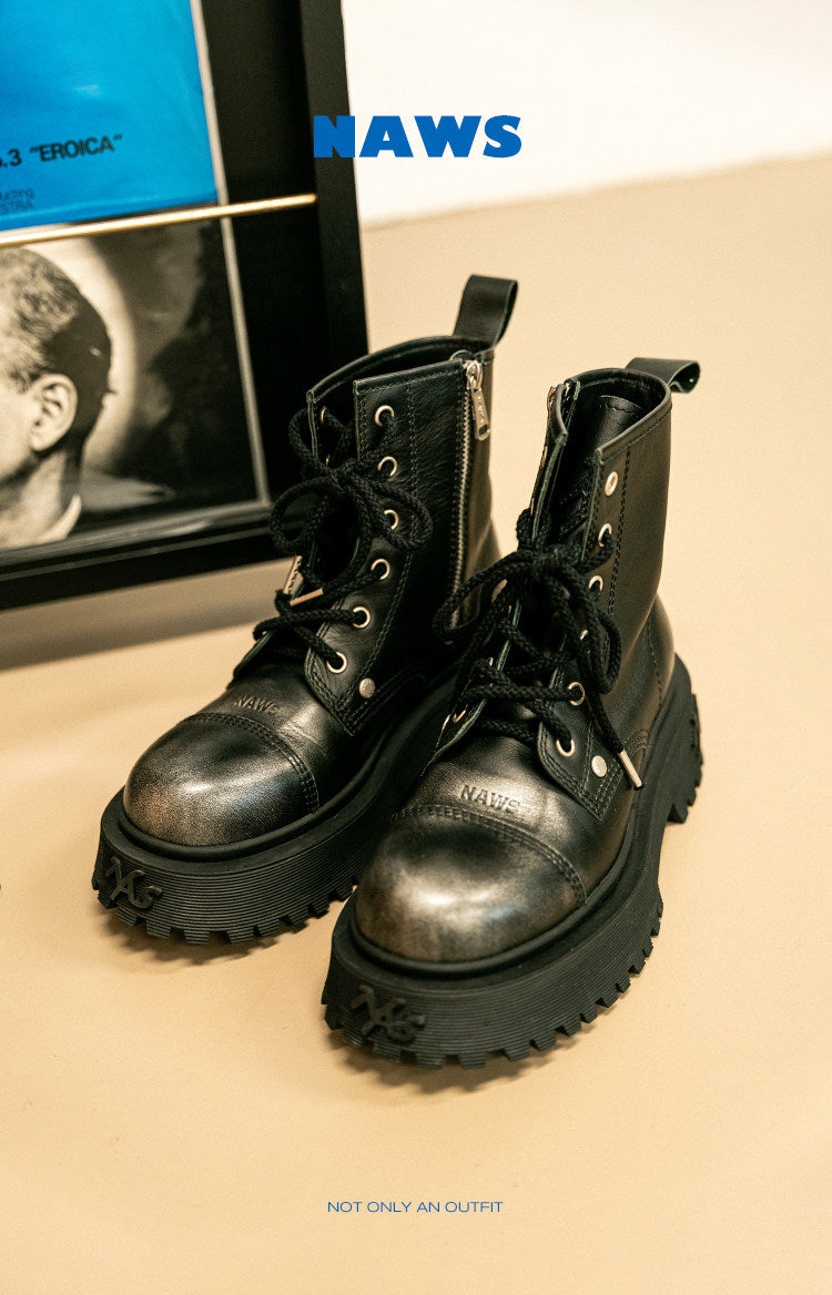 NAWS KNIGHT leather platform lace-up boots in SEA NIGHT BLACK — indoor styled view of both boots beside framed pictures.