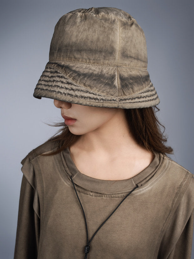 PIONEER distressed nylon bucket hat — mercury brown modeled view showing the unbranded back seam