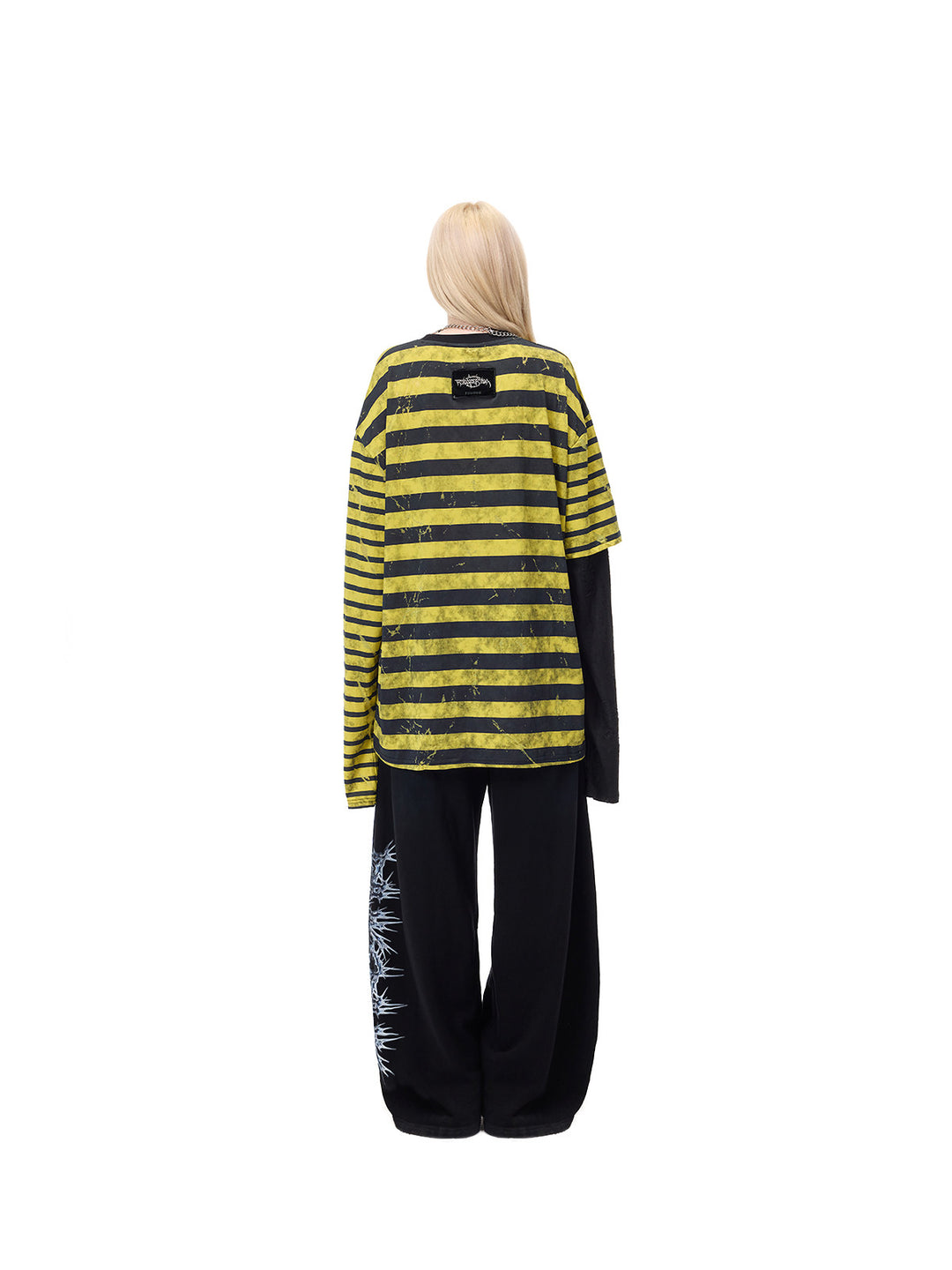 PINKSPINK STATIC asymmetric striped burnout long-sleeve tee in black and yellow — full-length rear modeled view over separate black trousers
