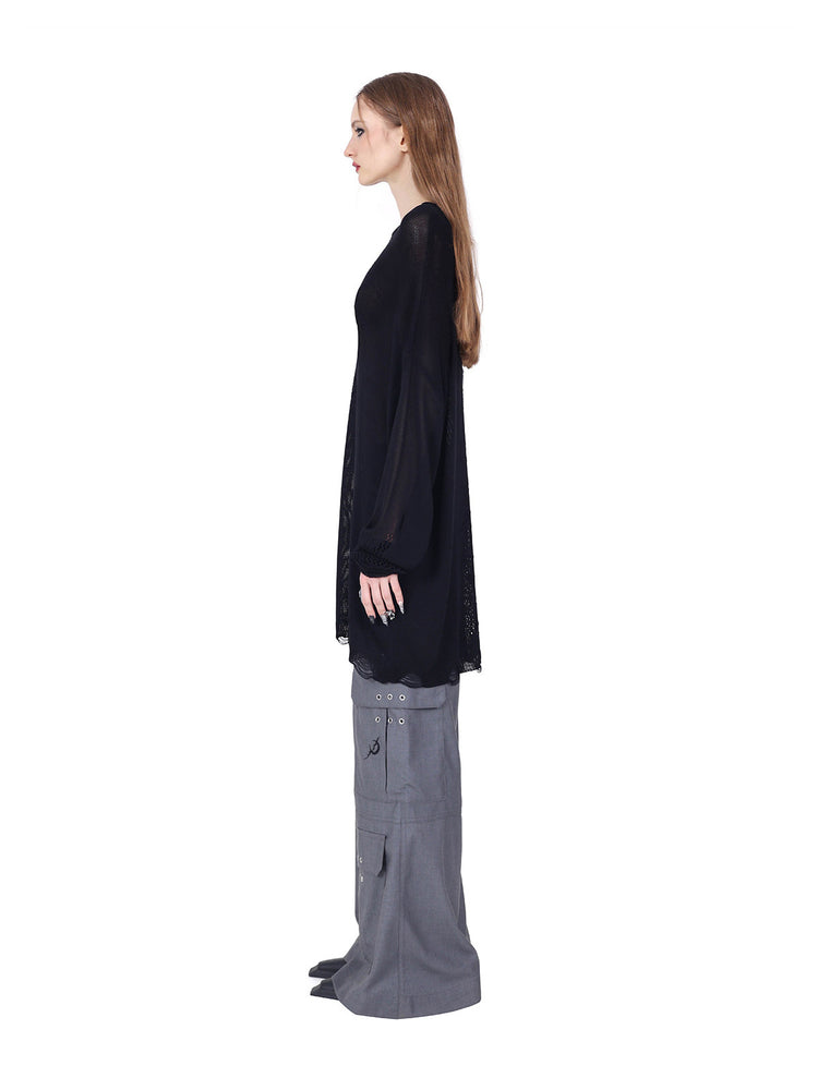 PINKSPINK ELECTRIC MOON distressed open-knit sweater in black — full-length side view styled with gray trousers