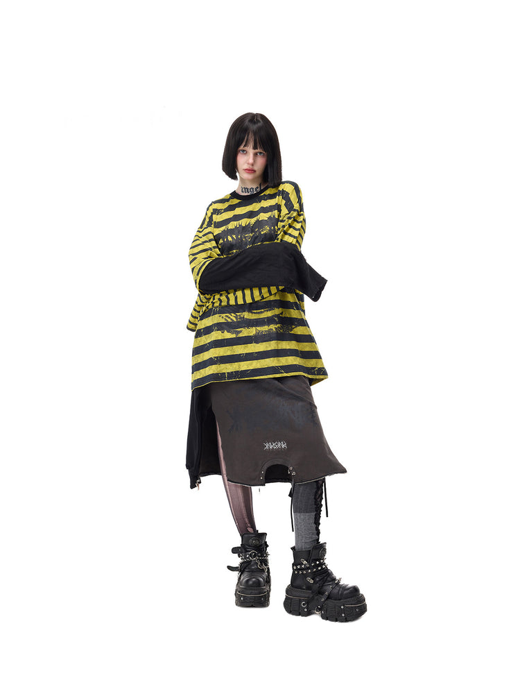 PINKSPINK STATIC asymmetric striped burnout long-sleeve tee in black and yellow — full-length front modeled view with arms crossed to show the long contrasting sleeve