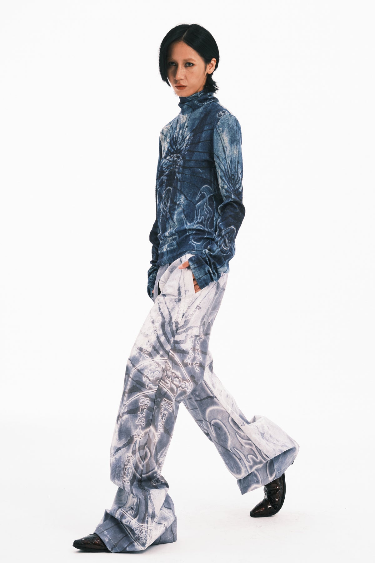 EMBRYO ANCIENT CODE coated wide-leg pants — side modeled view with one leg raised