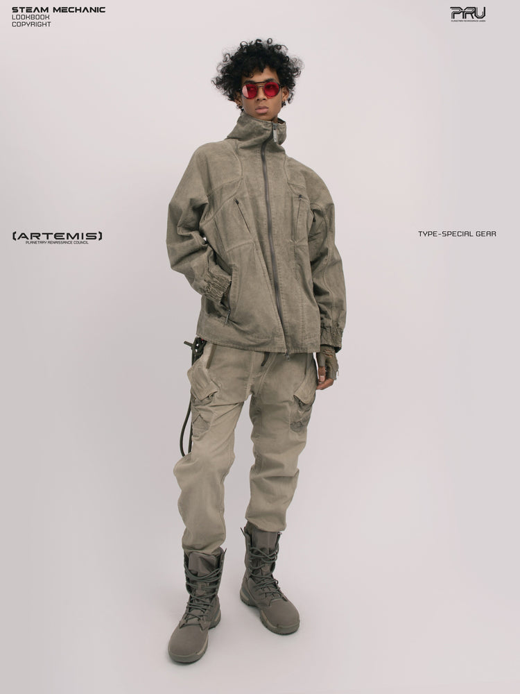 ARTEMIS xirang brown tuck-paneled technical jacket — full-length angled modeled front view with the collar zipped and one hand in a pocket