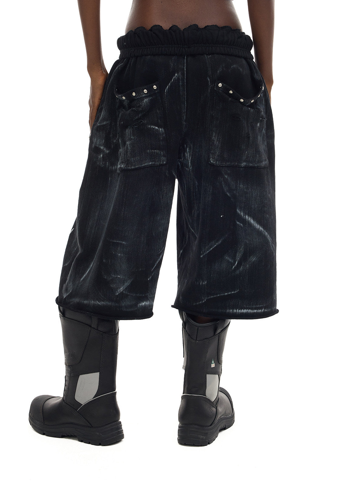 PINKSPINK ELECTRIC MOON coated cropped wide-leg pants in black — rear close-up showing the gathered waist and studded patch pockets