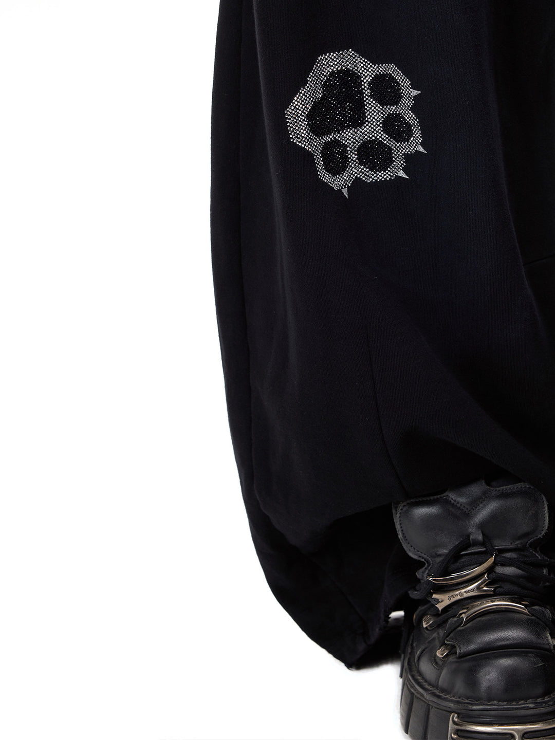 PINKSPINK CATPAW rhinestone curved-leg sweatpants in black — close lower-leg detail of the paw motif and curved seam