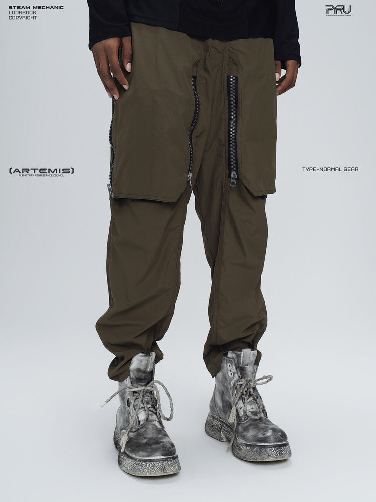 GAIA curved-blade technical pants in mountain green — three-quarter modeled view with the front pocket covers closed