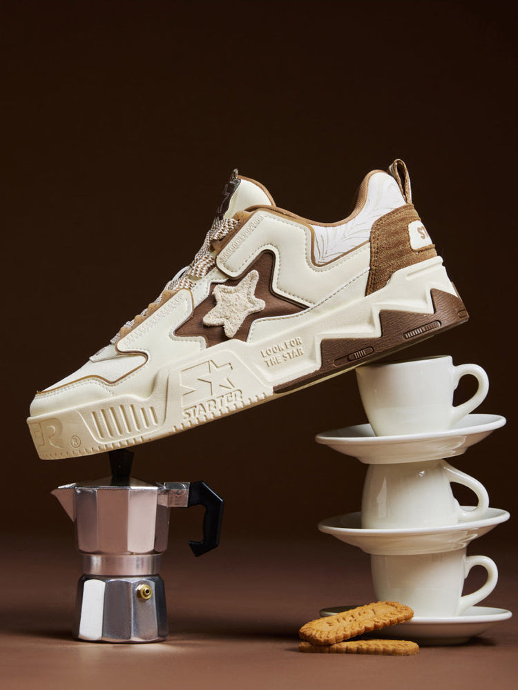 STARTER VOL 90S LATTE cream and brown sneaker balanced on coffee cups and a moka pot, showing its raised star and sculpted platform