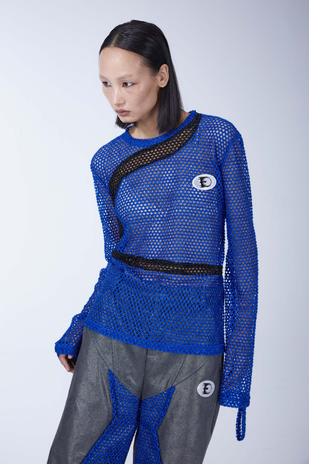 EMBRYO BLUE VOID cutout mesh finger-sleeve top — construction and silhouette detail