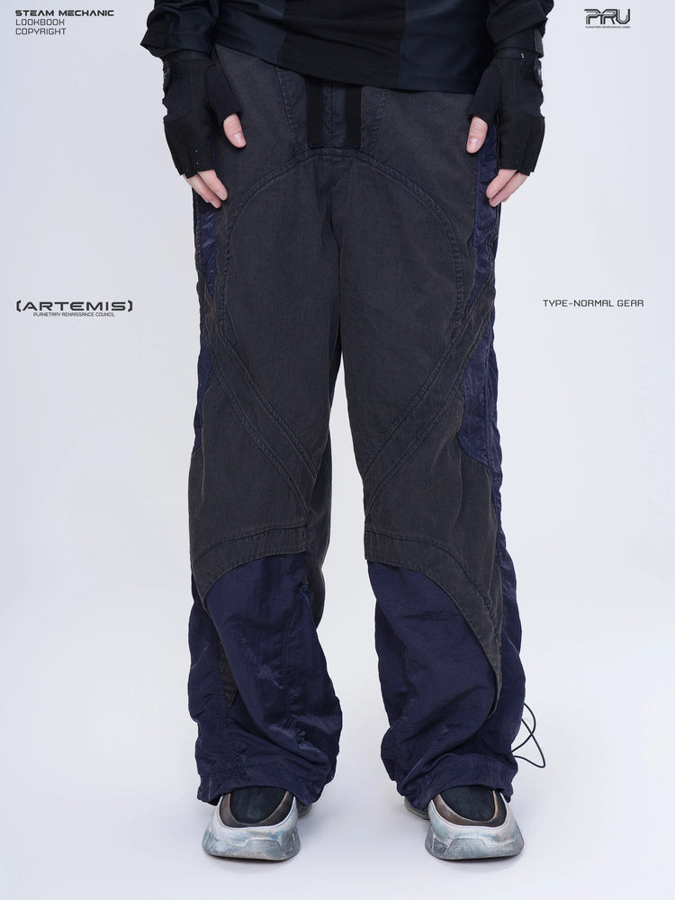 SUPERNOVA zima blue metallic nylon technical pants — front modeled close-up showing charcoal and blue panels