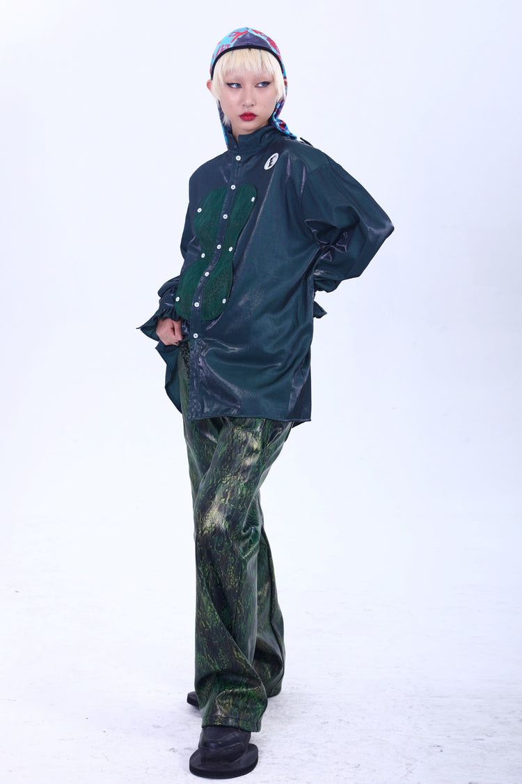 EMBRYO TRIANGLE ARMOR lace-inset leather pants in green — front modeled outfit with hands behind the green overshirt