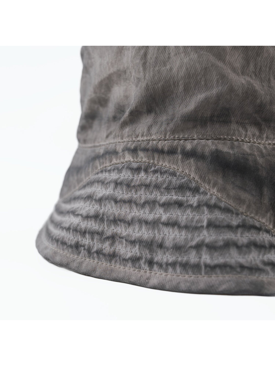 PIONEER distressed nylon bucket hat in moon dust gray — close-up of stitched brim and washed fabric