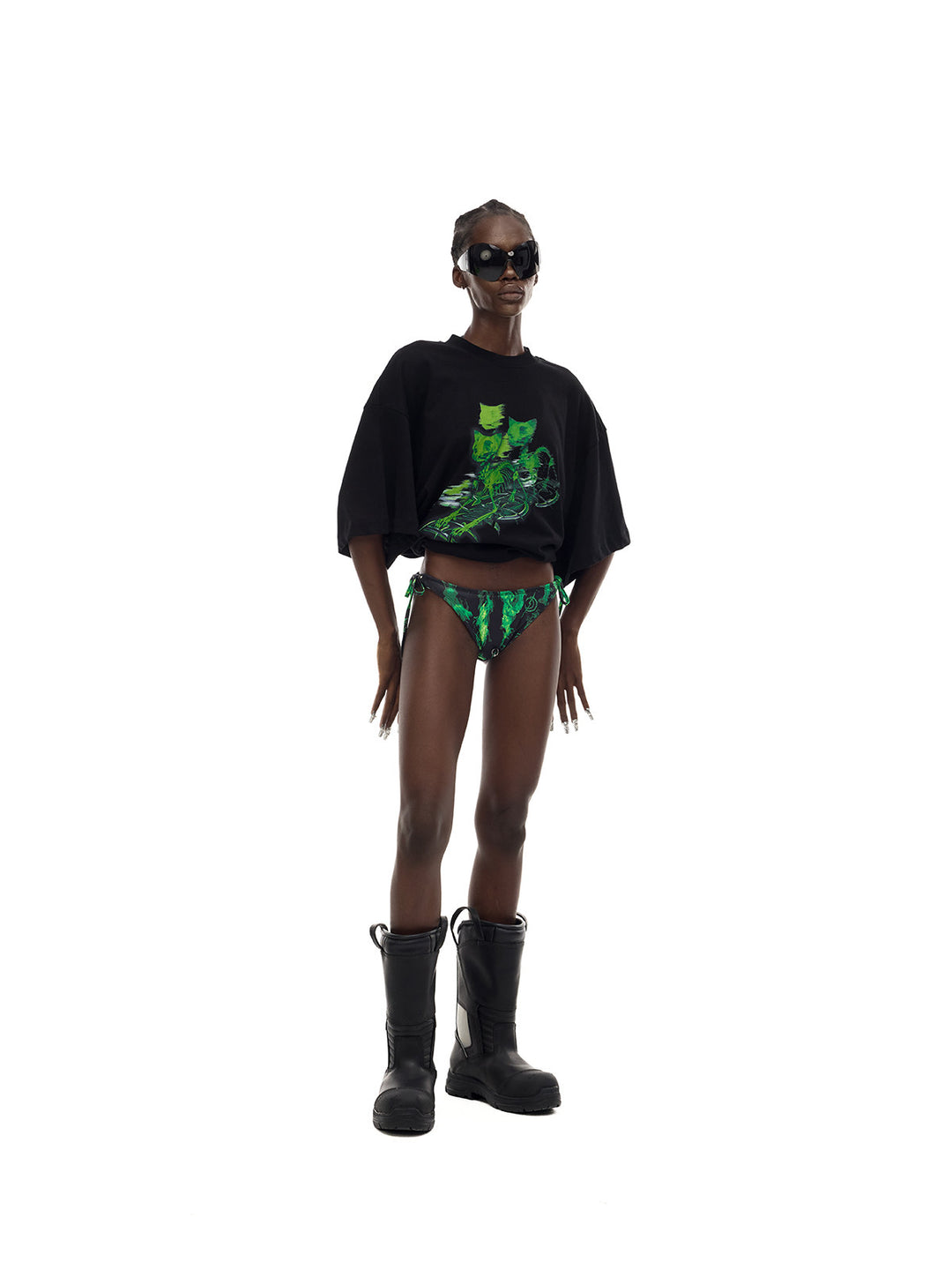 PINKSPINK MONSTER cat-skeleton oversized graphic tee in black — angled full-length front modeled view with hands at the sides and the hem rolled up