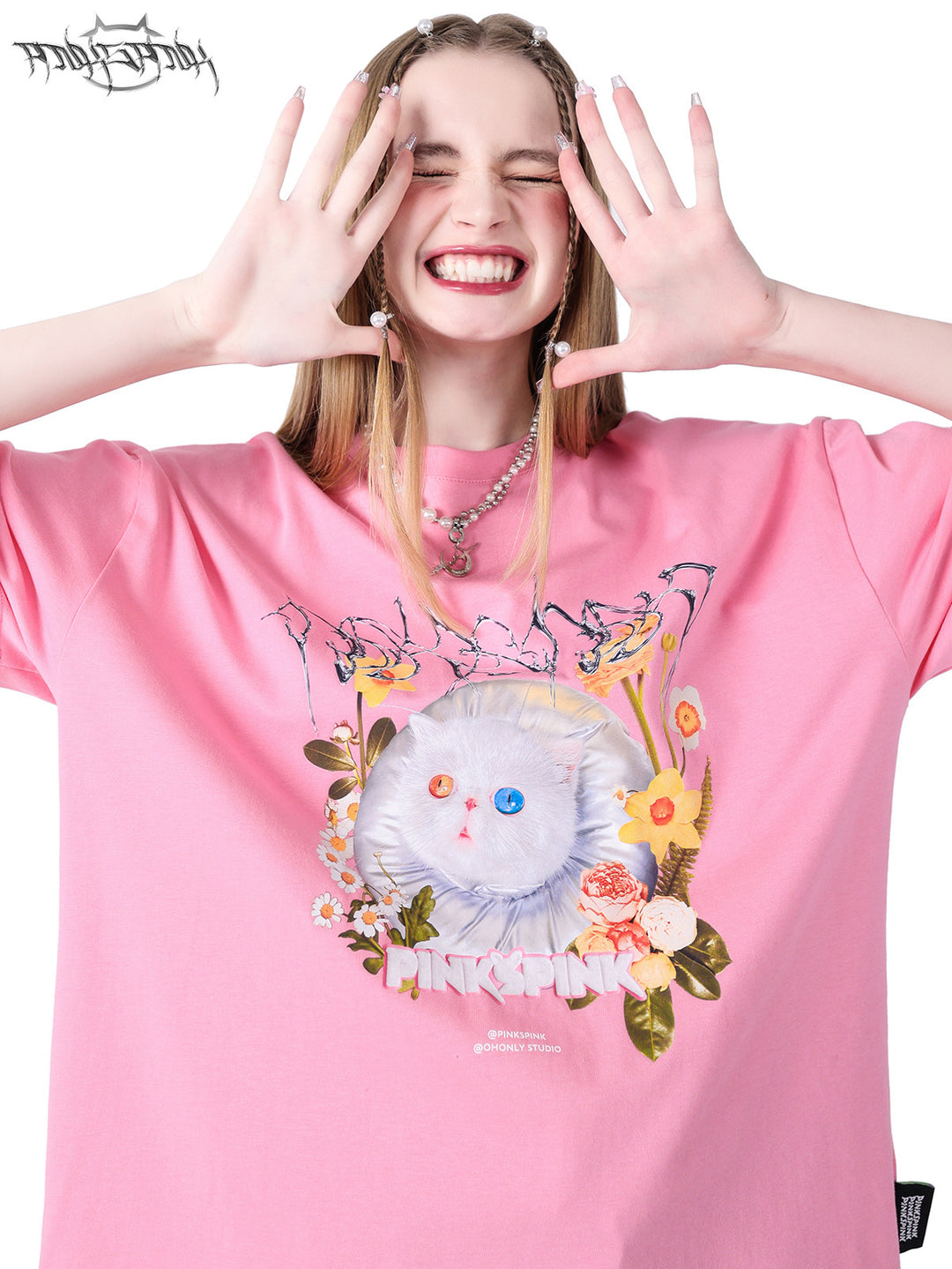 PINKSPINK GARFIELD oversized graphic tee — pink close-up with both hands raised beside the face