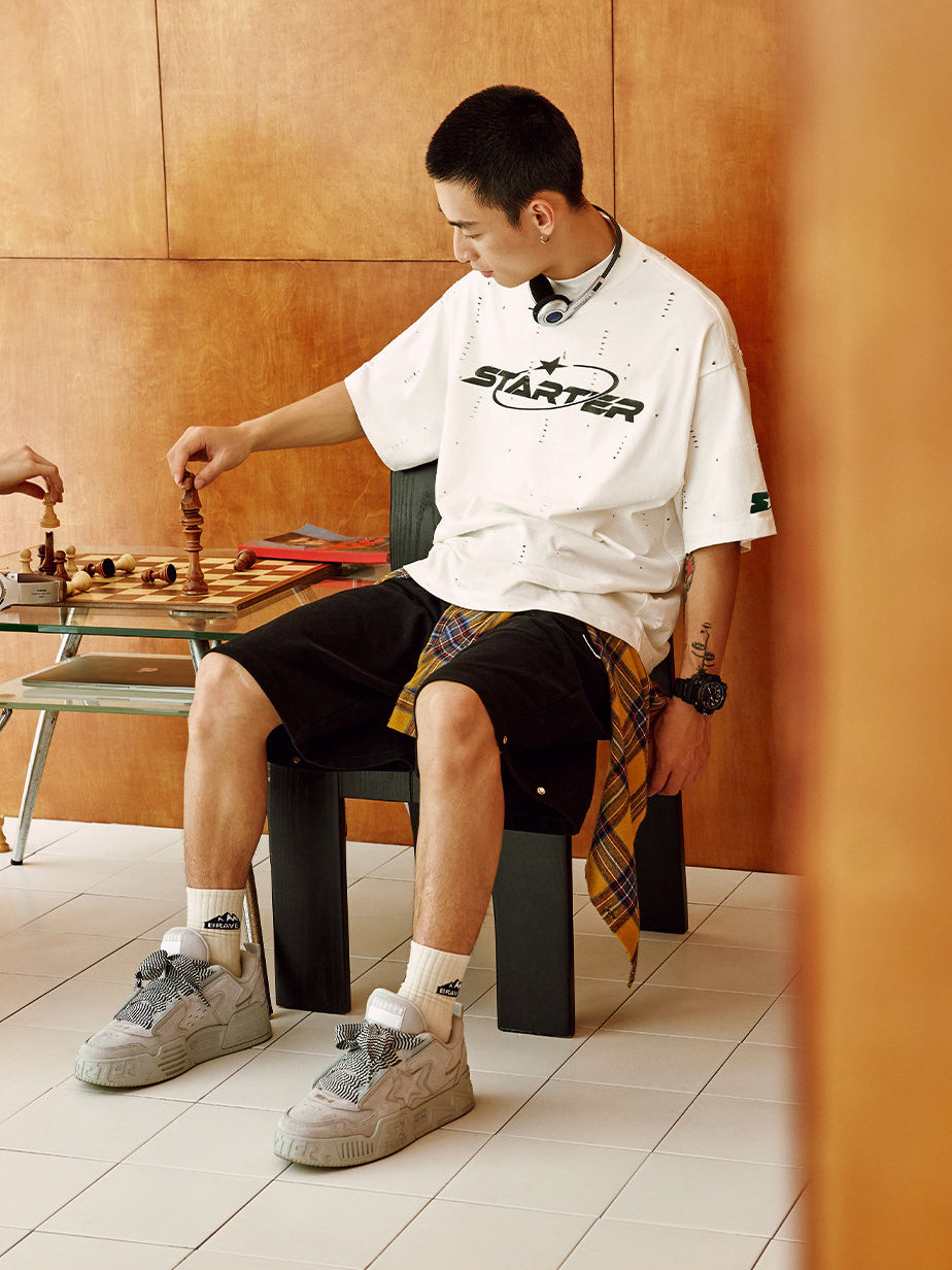 STARTER VOL 90S SONIC Gray sneakers styled with relaxed trousers beside a chess table