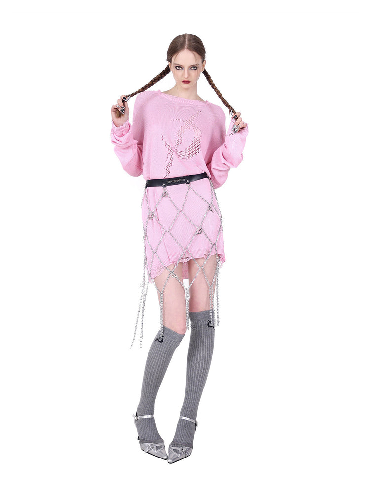 PINKSPINK ELECTRIC MOON distressed open-knit sweater in pink — front modeled pose with braids held apart and a separate chain belt
