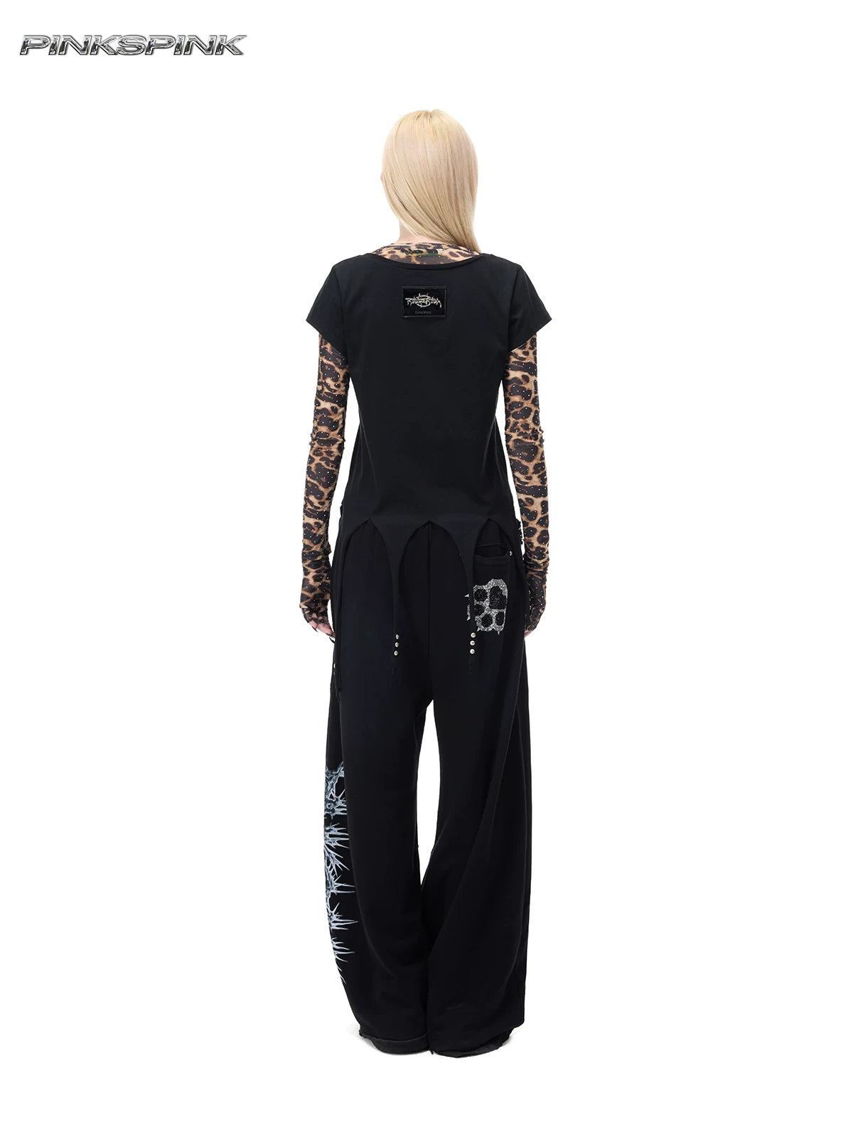 PINKSPINK PUNK CACTUS studded pointed-hem tee in black — full-length rear modeled view over a separate leopard mesh layer and black trousers