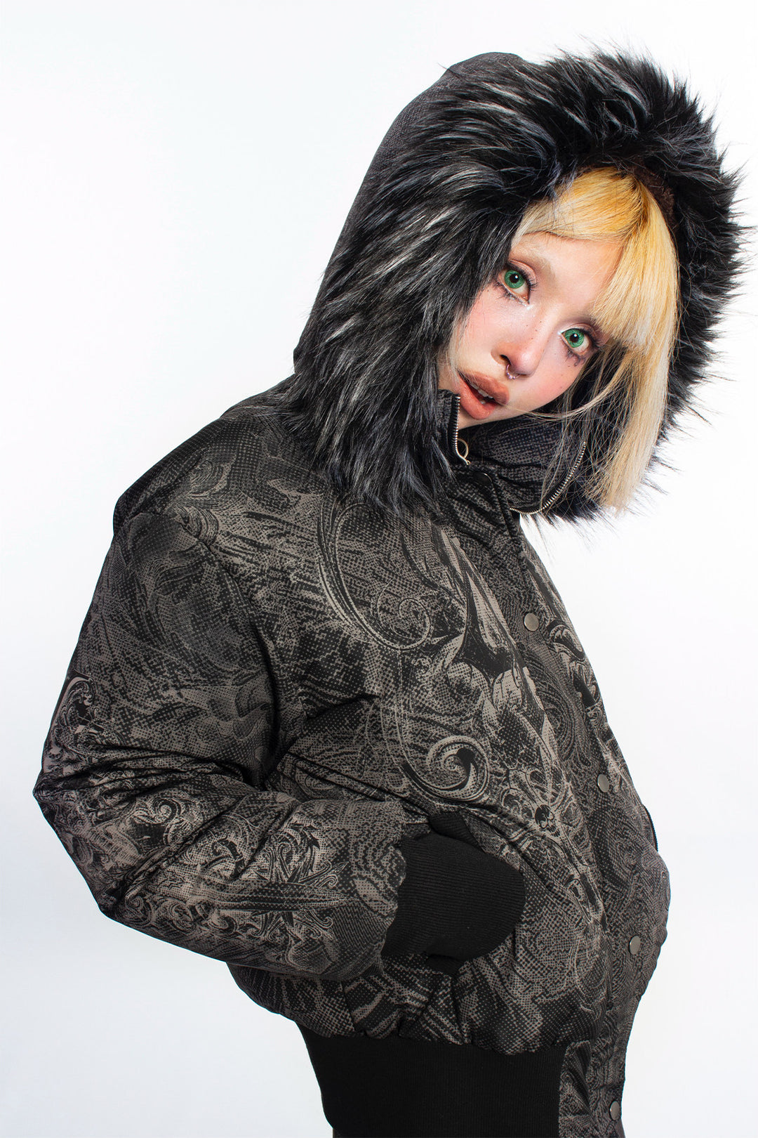 4RE1GN GOTHIC down jacket in charcoal ornamental print — Hood-up side three-quarter close-up with hand in pocket.