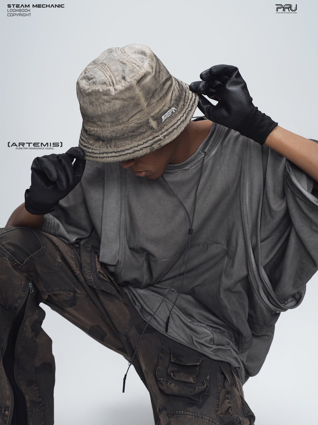 PIONEER distressed nylon bucket hat — close overhead modeled view of the mercury brown crown and textured brim
