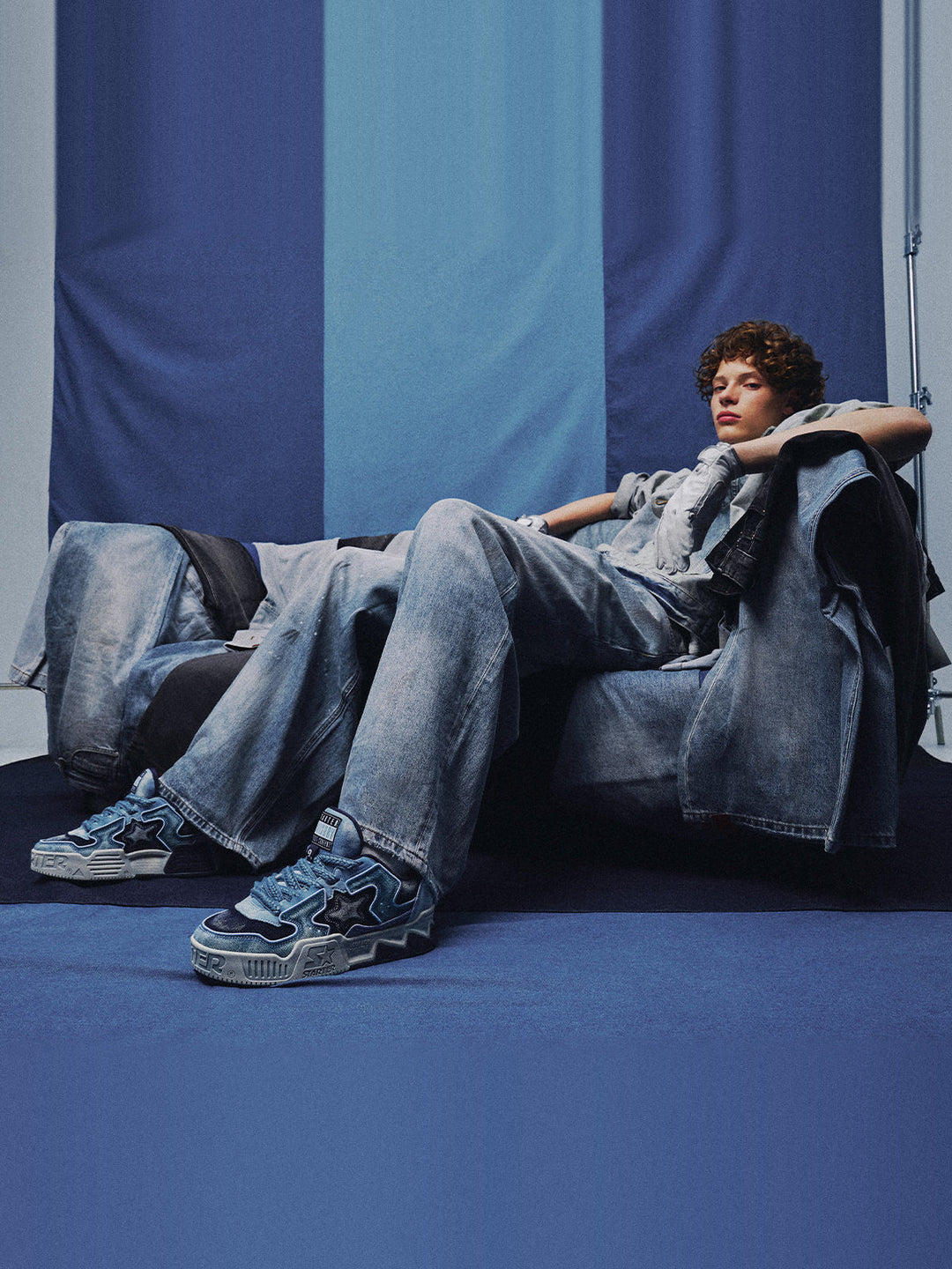 STARTER VOL 90S Denim Blue platform sneakers worn with washed denim, relaxed seated full-body view