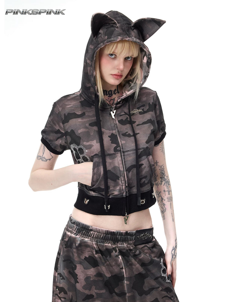 PINKSPINK CATPAW cropped cat-ear zip hoodie in gray-brown camouflage — front three-quarter modeled view with hood up and one hand in a pocket