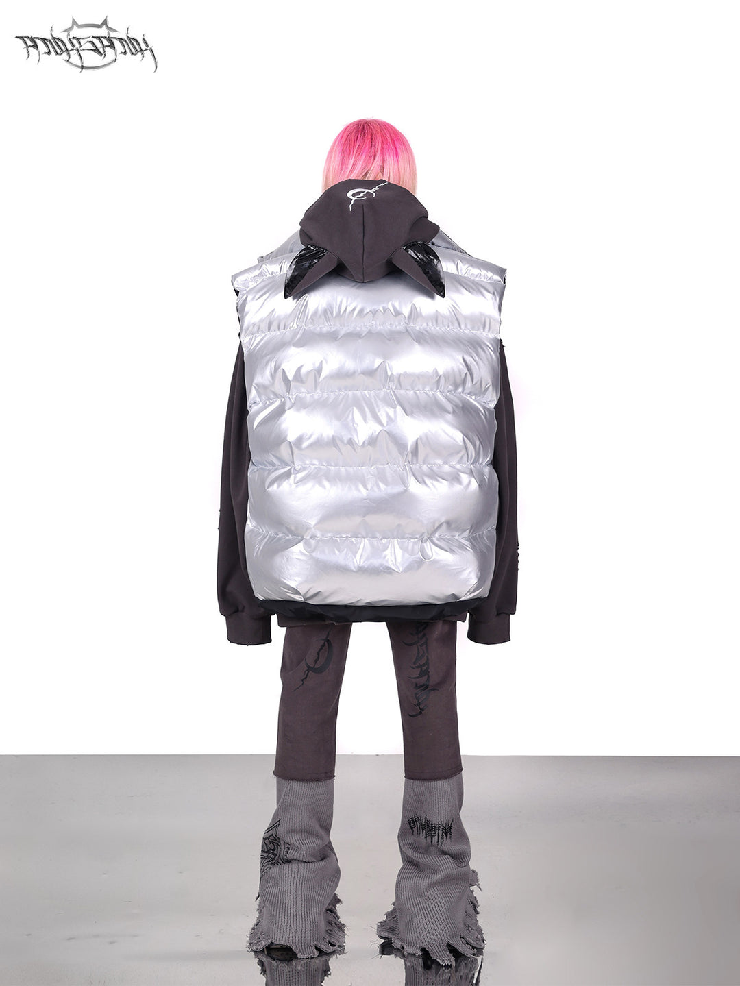 PINKSPINK ORBIT reversible padded vest in black silver — silver-side rear modeled view layered over a gray hoodie