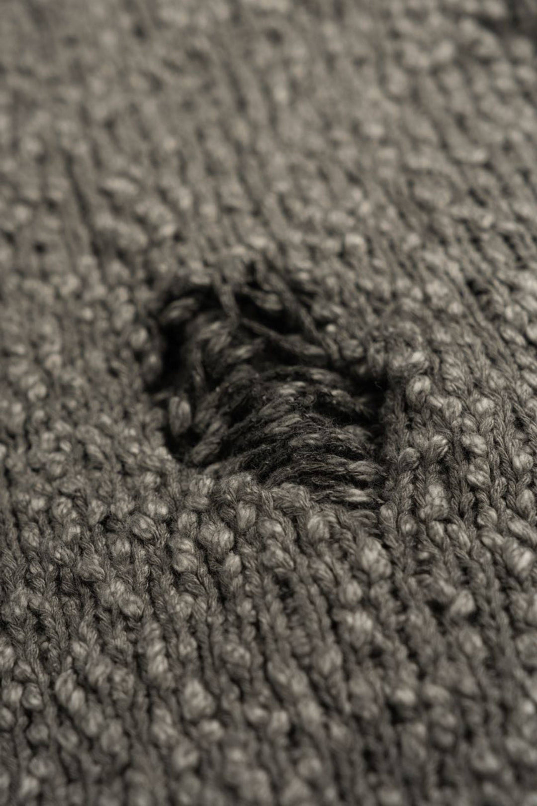 ARTEMIS distressed reversible knit sweater, close-up of a single distressed opening and the surrounding knit stitches