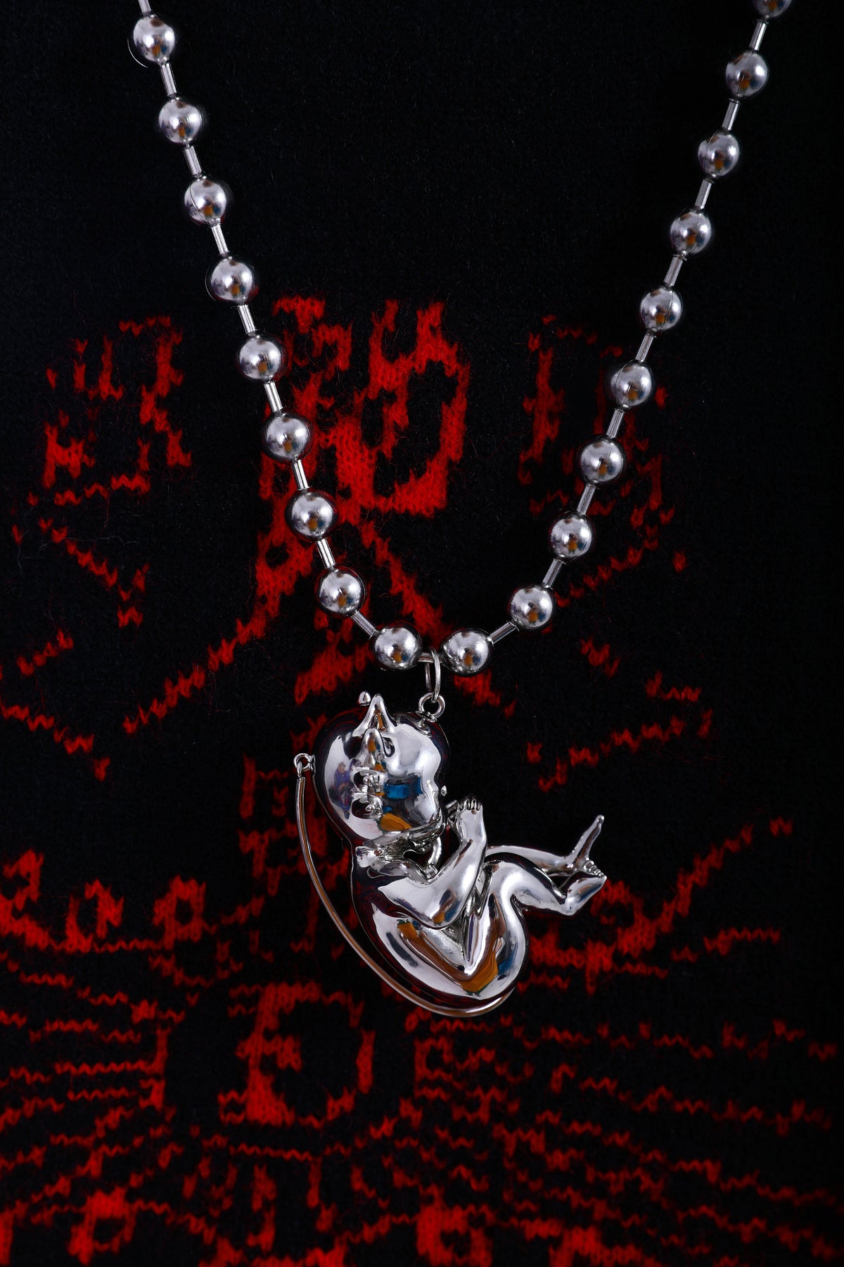 EMBRYO DEVIL CHILD sculptural pendant necklace — full-length modeled view
