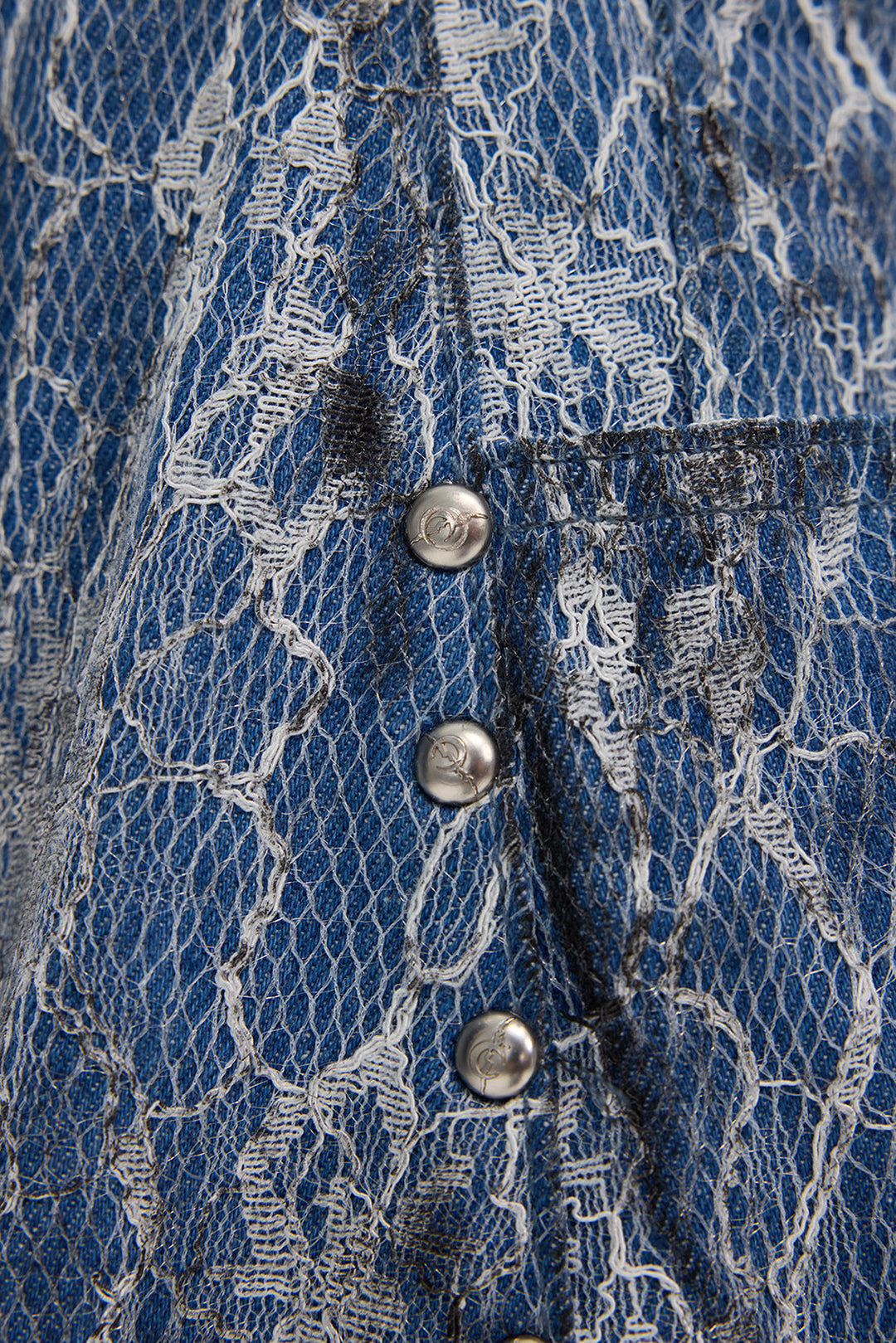 PINKSPINK ELECTRIC MOON lace-coated wide-leg denim shorts in blue — macro detail of the pale lace-coated texture and silver-tone studs