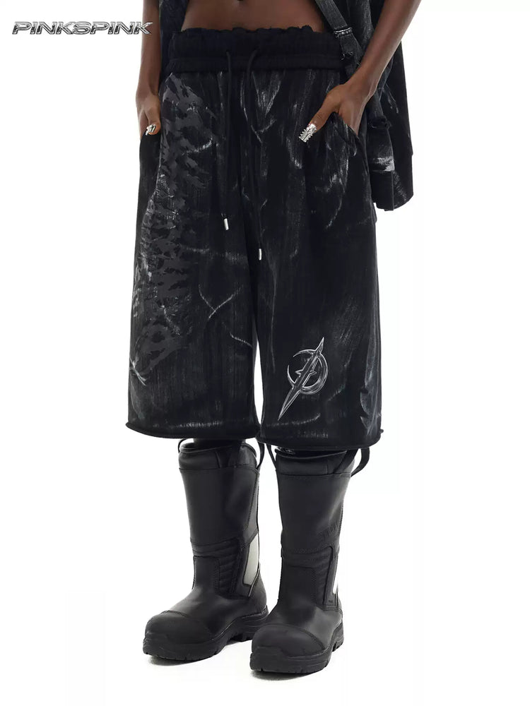 PINKSPINK ELECTRIC MOON coated cropped wide-leg pants in black — front modeled close-up showing the coated finish, drawstring waist and electric-moon graphic