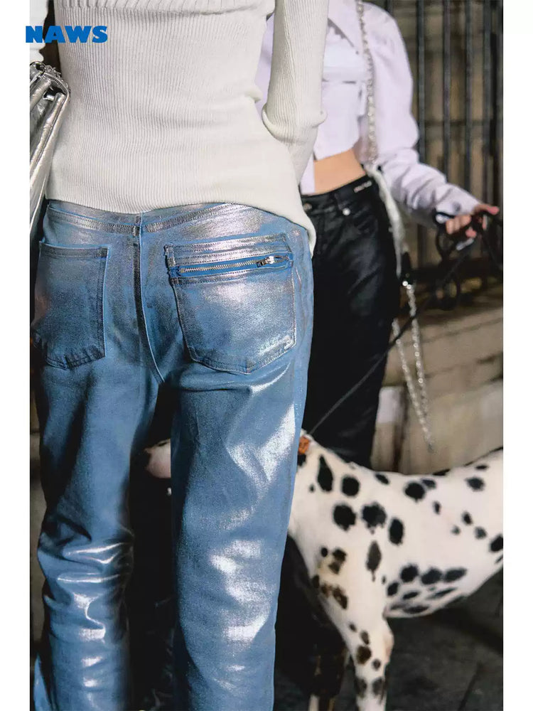 NAWS wax-coated zip-hem jeans in GLACIER LAKE BLUE — indoor close-up of the metallic coating and rear zip pocket.