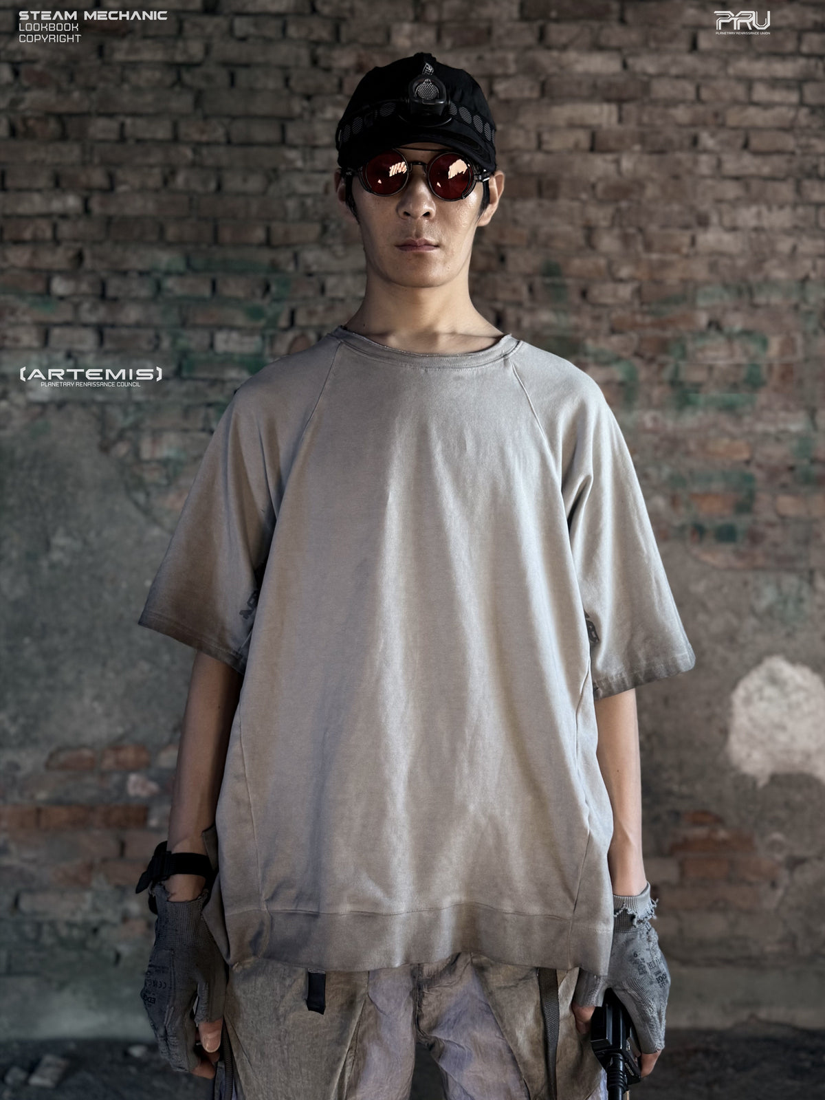 ERODED SPINE distressed asymmetric tee in oxidized white — front modeled view against a brick wall