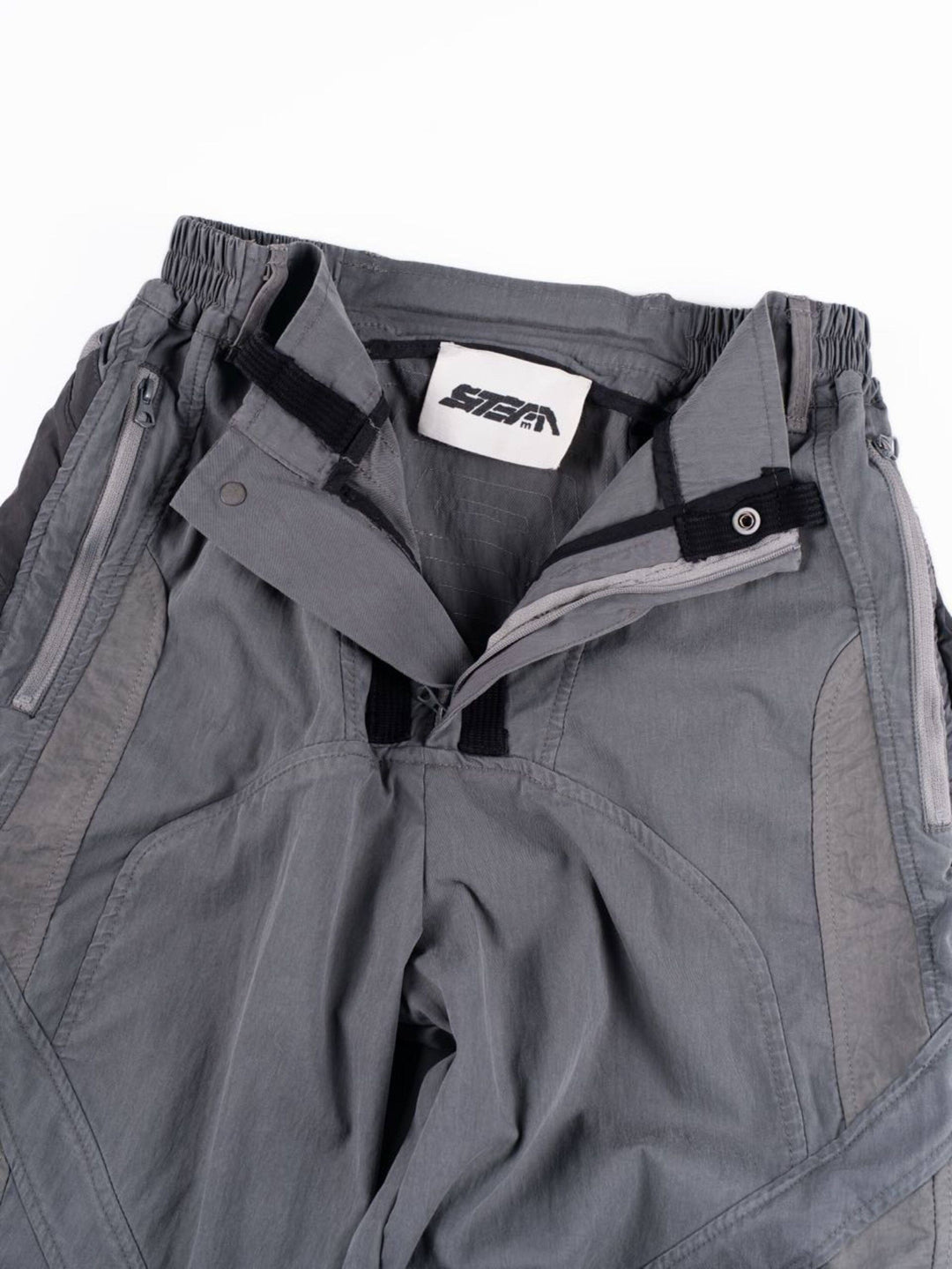SUPERNOVA alloy gray metallic nylon technical pants — alloy gray open-waist detail showing fly construction and pocket lining
