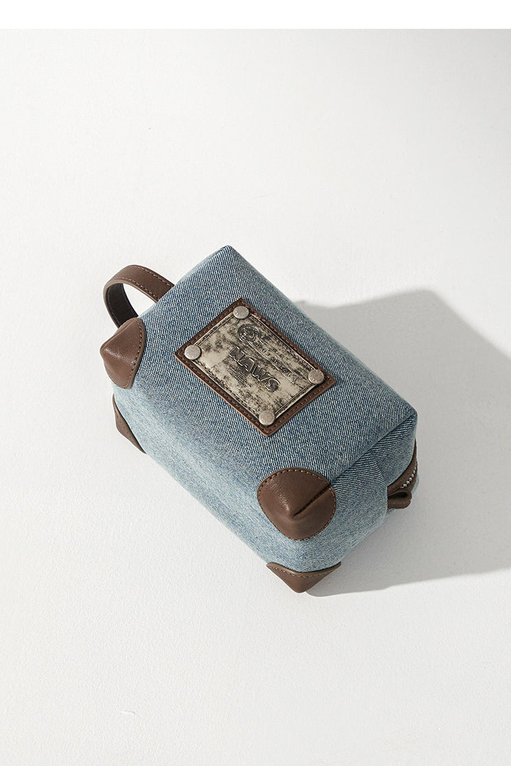 NAWS BLUE BOX denim makeup bag — modeled detail view of the garment construction
