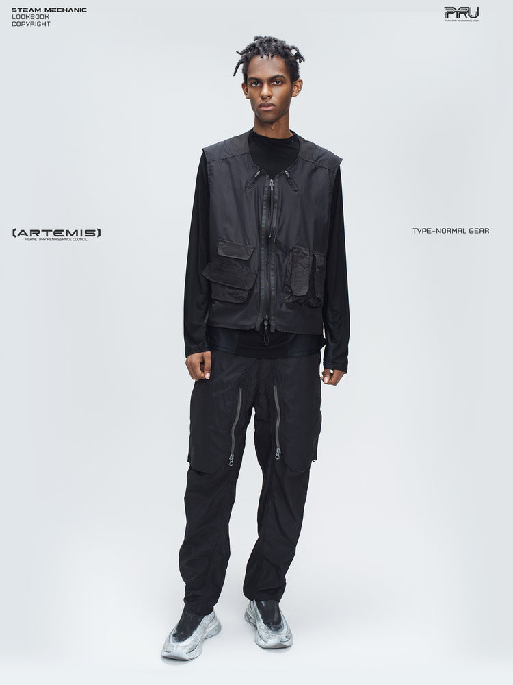 GAIA curved-blade technical pants in black — full-length front styling view with a matching utility vest