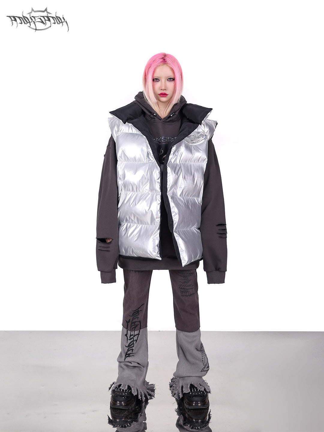 PINKSPINK ORBIT reversible padded vest in black silver — silver-side front full-length modeled view layered over a gray hoodie