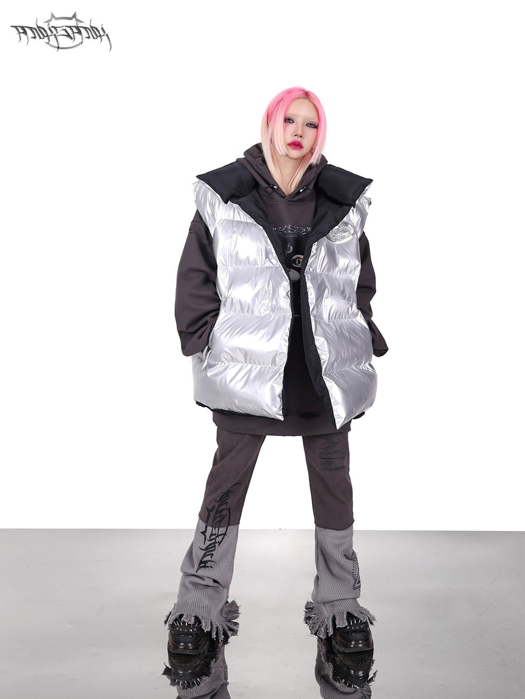 PINKSPINK ORBIT reversible padded vest in black silver — silver-side full-length modeled view layered over a gray hoodie