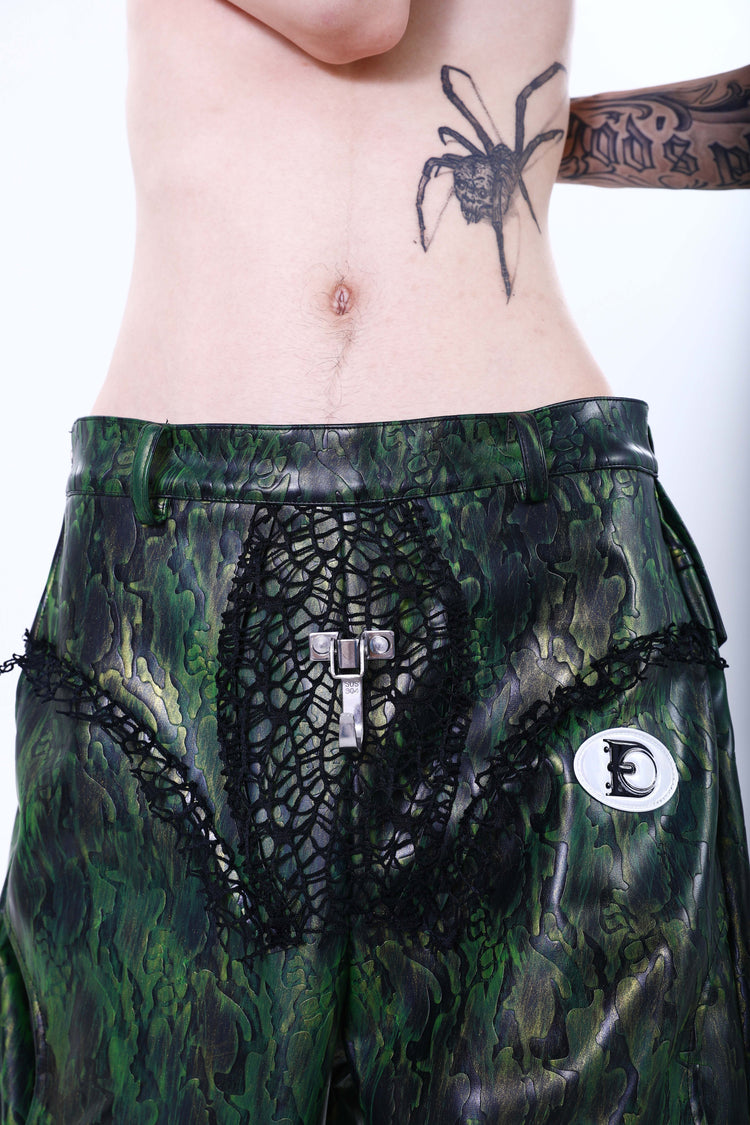 EMBRYO TRIANGLE ARMOR lace-inset leather pants in green — straight-on front waist detail showing the lace inserts and metal clasp