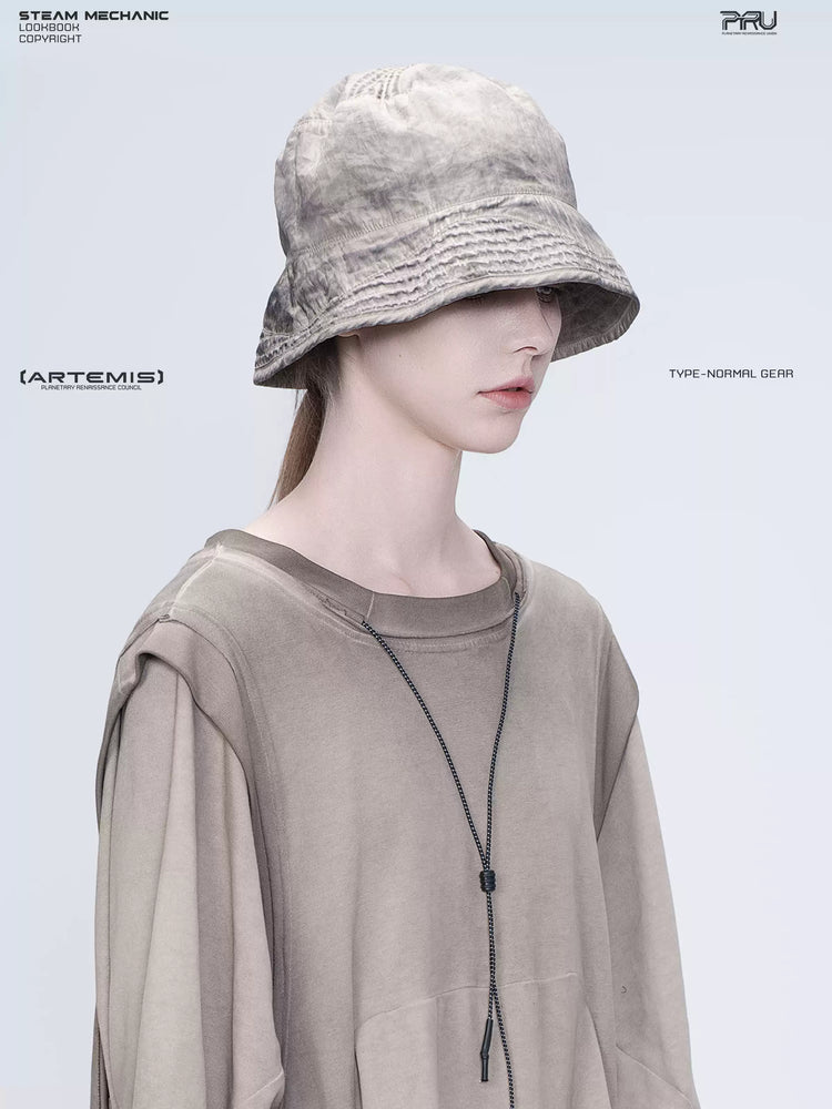 PIONEER mercury brown distressed nylon bucket hat — three-quarter portrait showing the washed nylon texture