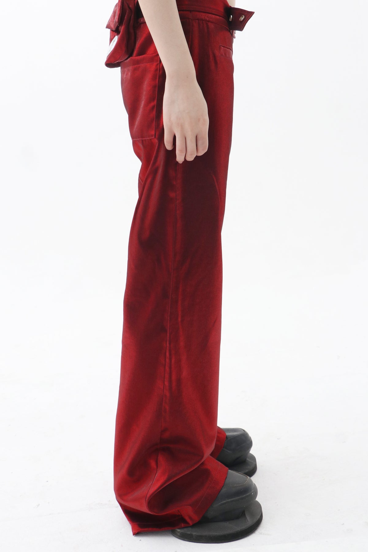 EMBRYO FIVE POISONS red color-shift low-rise pants — side modeled close-up showing the waistband and leg shape