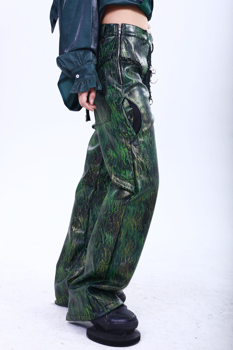 EMBRYO TRIANGLE ARMOR lace-inset leather pants in green — full-length side modeled view showing the curved hip pocket