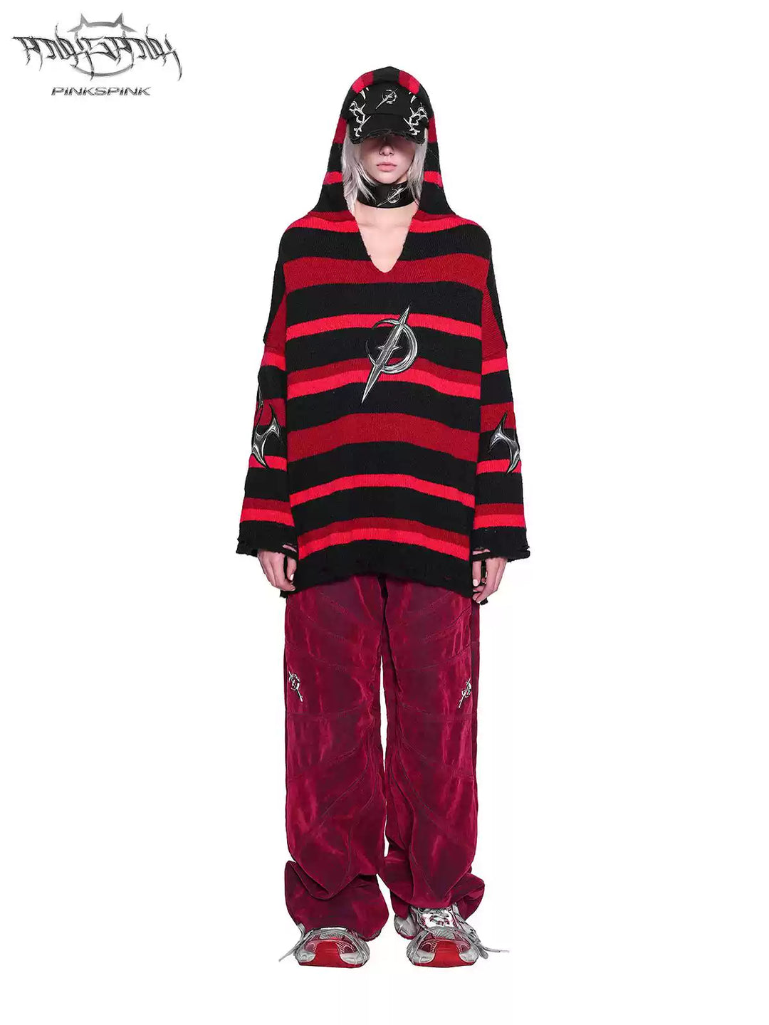 PINKSPINK ELECTRIC MOON striped hooded sweater in BLACK AND RED — full-body front view with hood over cap and red trousers.