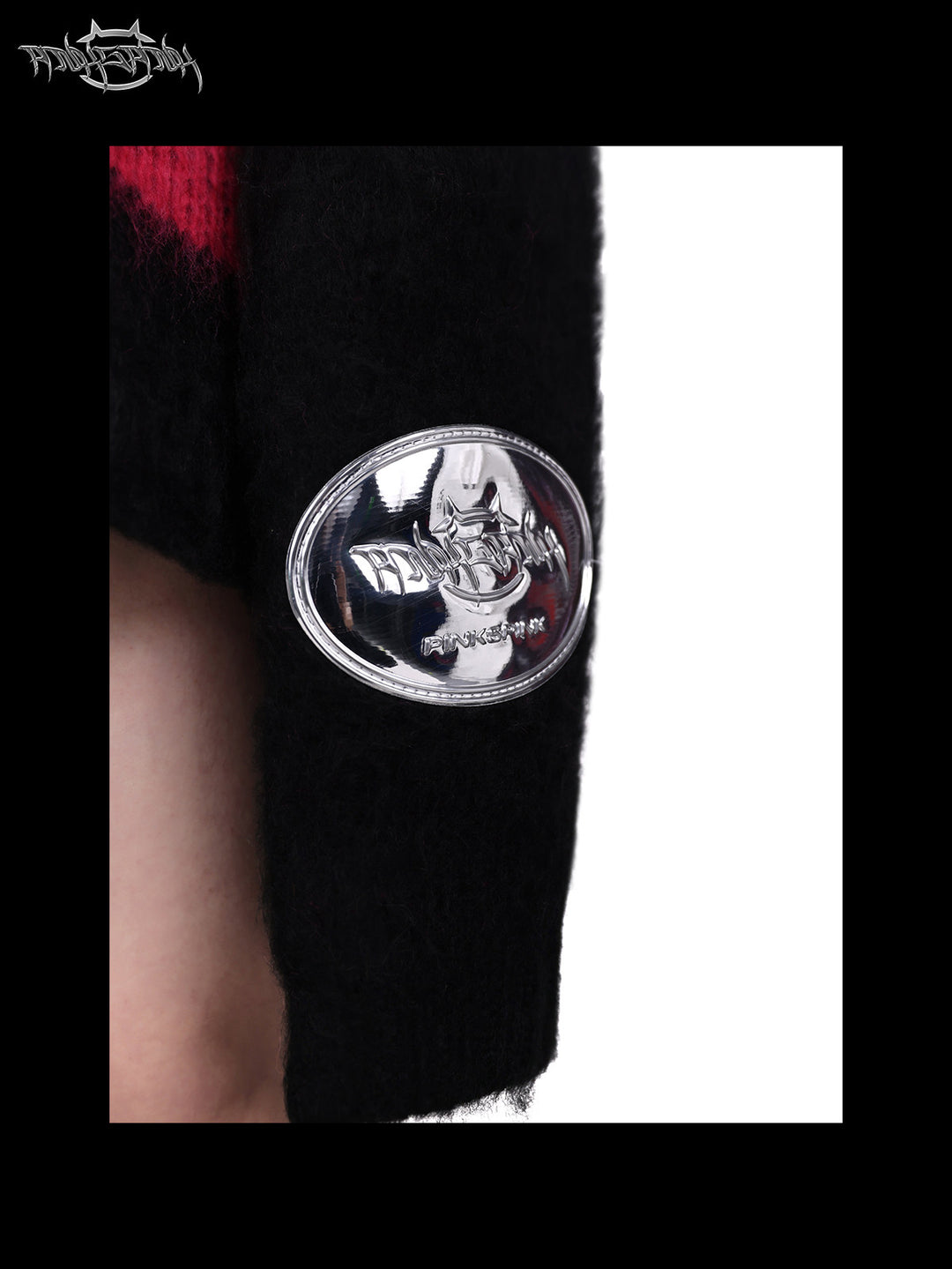 PINKSPINK ELECTRIC MOON black-pink striped sweater in black pink — close-up of the silver-tone sleeve badge
