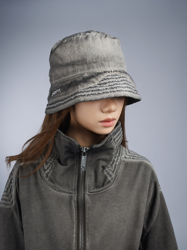 PIONEER distressed nylon bucket hat — moon dust gray modeled three-quarter front view
