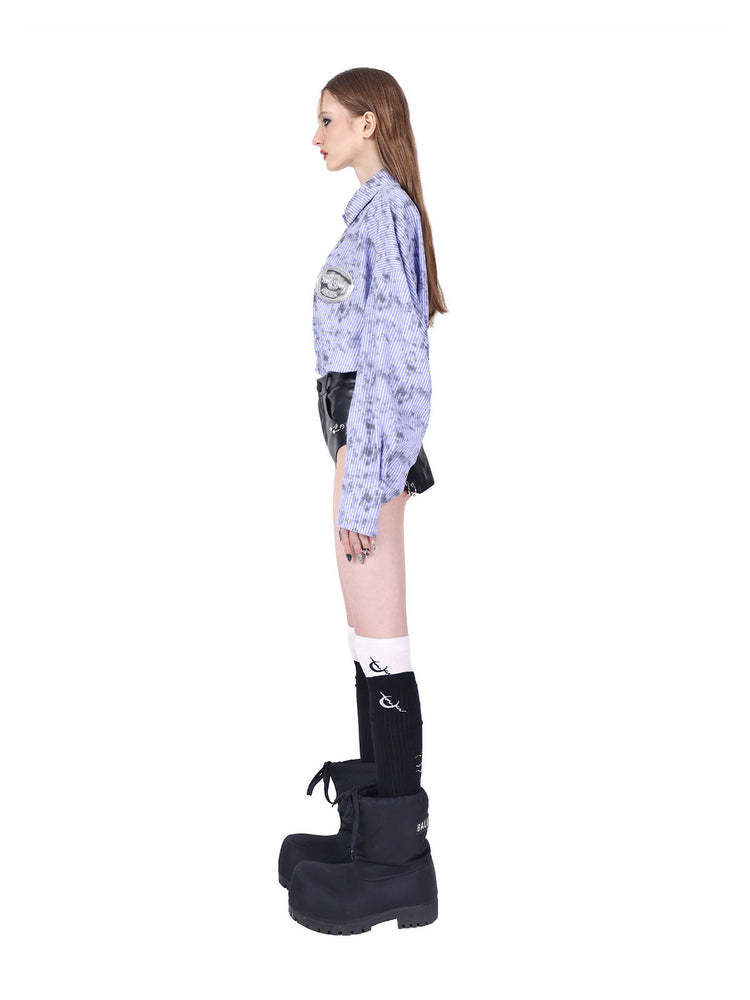 PINKSPINK REBEL ring-pierced faux-leather hotpants in black — full side view showing the fitted shape and curved leg opening