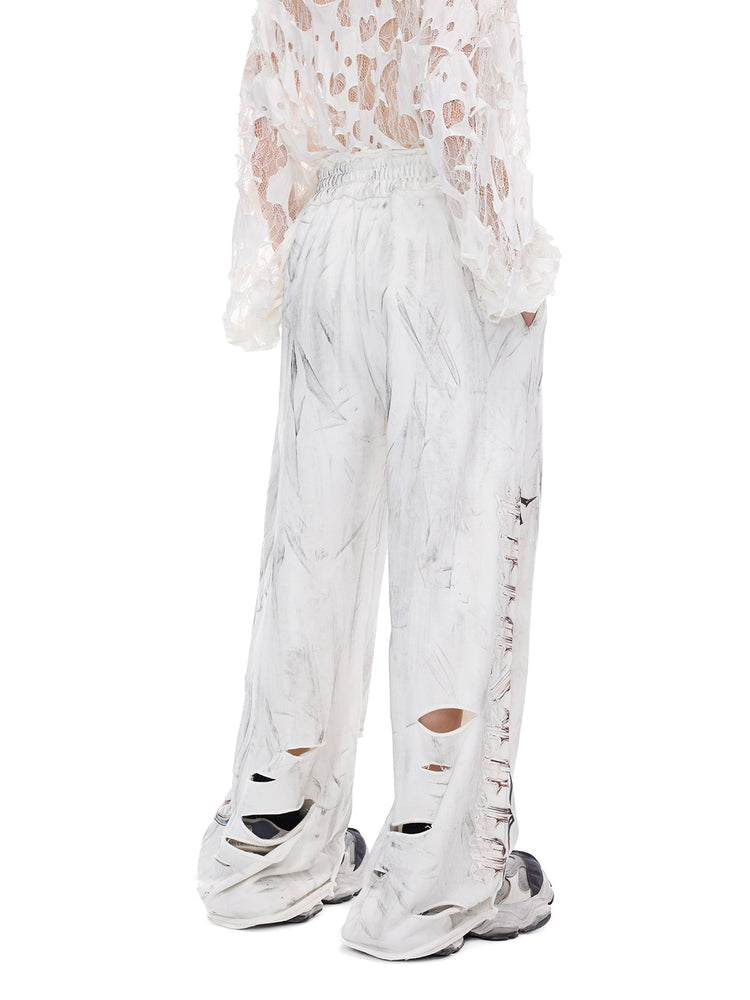 PINKSPINK ELECTRIC MOON coated distressed flare sweatpants — modeled detail view of the garment construction